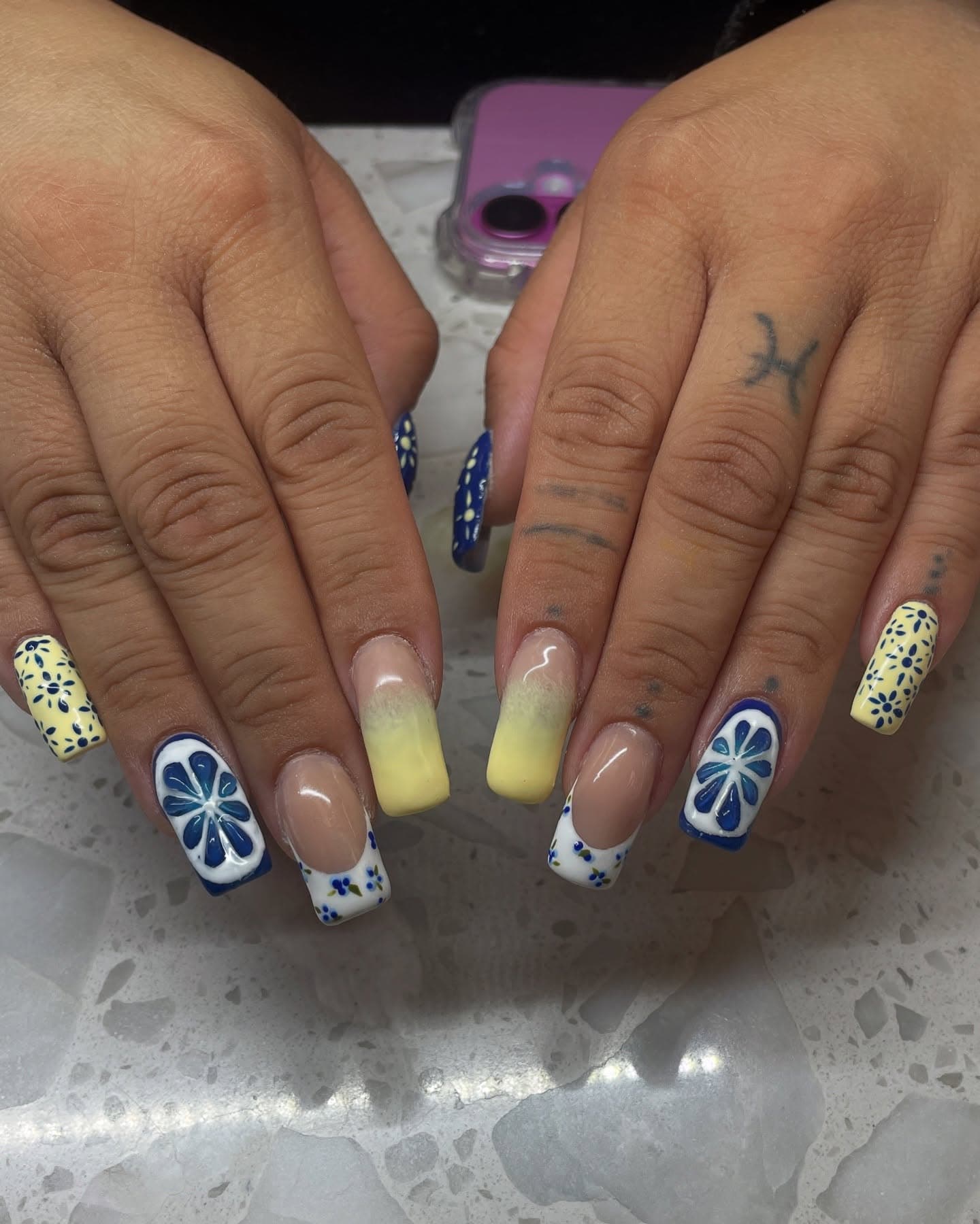 Long square nails in a blue and lemon-yellow set featuring painted citrus slices, ditsy navy flowers and floral French tips